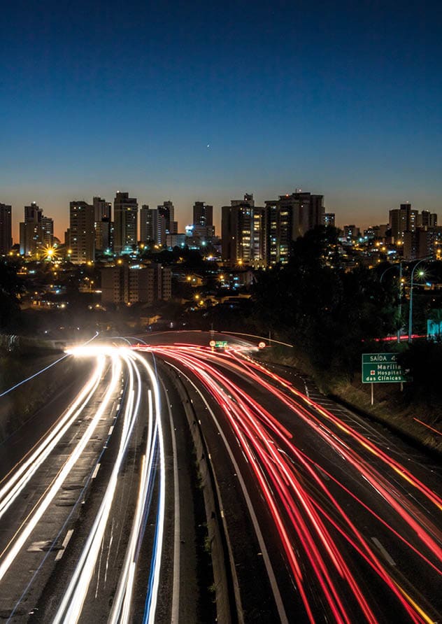Marilia, Sao Paulo, Brazil, June 12, 2019  Trail of light caused by vehicular traffic in SP-294, Comandante Joao Ribeiro Barros Highway with buildings from downtown in the background, in MarÃ lia,
